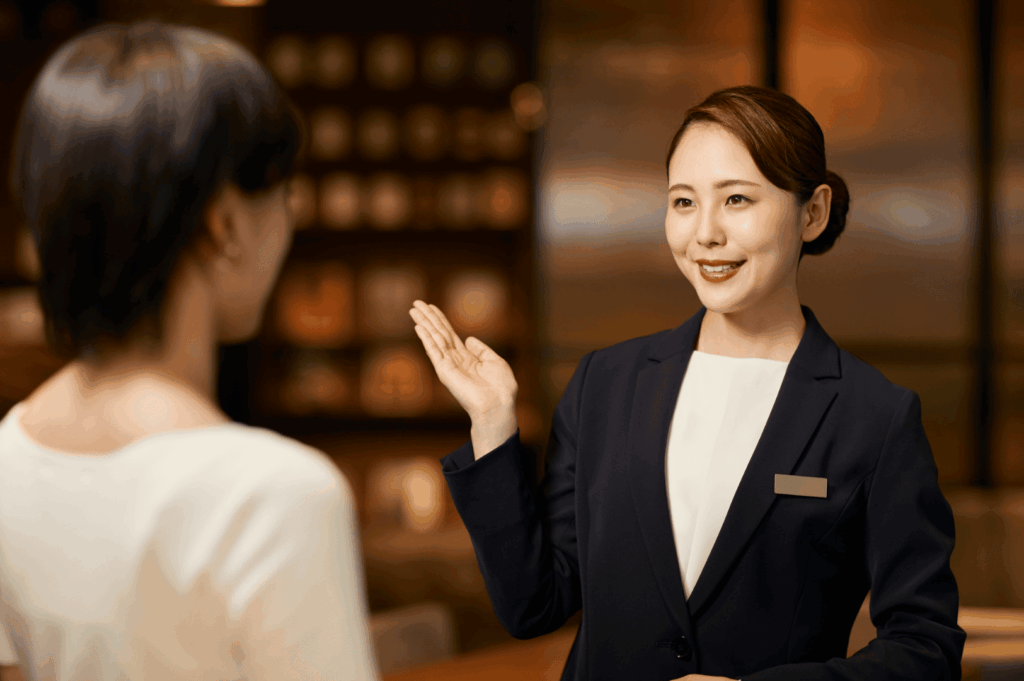 Hospitality staff member in a navy blazer warmly assisting a guest in a refined hotel or restaurant setting—capturing the professionalism, service quality, and guest engagement that contribute to michelin star recognition. This moment reflects the human touch behind michelin star restaurants, where michelin inspectors evaluate not only exceptional cuisine and innovative dishes, but also the overall dining experience. As outlined in the michelin star restaurant guide, fine dining establishments like Summer Pavilion, Saint Pierre, and those at Marina Bay or Ion Orchard strive for one michelin star, two michelin stars, or three michelin stars by delivering culinary excellence, premium ingredients, and personalized service. World renowned chefs such as chef louis han, chef yew eng tong, head chef takuya yamashita, chef owner emmanuel stroobant, chef denis lucchi, and chef christophe lerouy lead culinary journeys that blend global influences, japanese cuisine, and the chef’s personality. Michelin introduced the michelin green star and bib gourmand to honor sustainability and good restaurant practices in the hospitality industry, while all the restaurants featured in the michelin guide aim to create unforgettable dining experiences through teamwork, seasonal produce, and exceptional hospitality.