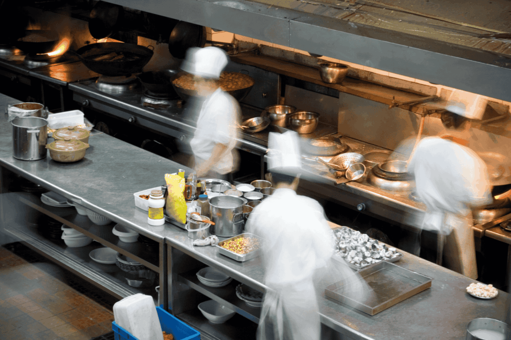 A bustling commercial kitchen with chefs in white uniforms rapidly preparing dishes—capturing the behind-the-scenes intensity of a fine dining restaurant striving for michelin star recognition. This image reflects the culinary excellence, cooking techniques, and teamwork required to earn one michelin star, two michelin stars, or even three michelin stars, as evaluated by michelin inspectors using the five criteria outlined in the michelin guide. Featuring premium ingredients, seasonal produce, and innovative dishes, this fine dining establishment embodies the culinary journey of world renowned chefs like chef louis han, chef yew eng tong, head chef takuya yamashita, chef owner emmanuel stroobant, chef denis lucchi, and chef christophe lerouy. From lunch menu to tasting menu, restaurants such as Summer Pavilion, Saint Pierre, and those at Marina Bay or Ion Orchard offer diners exceptional cuisine and great dishes that reflect the chef’s personality, global influences, and gastronomic excellence. Michelin introduced the michelin green star and bib gourmand to honor sustainability and excellence in the hospitality industry, while young chefs and sous chefs continue to pursue their first michelin star in this high-pressure culinary haven.