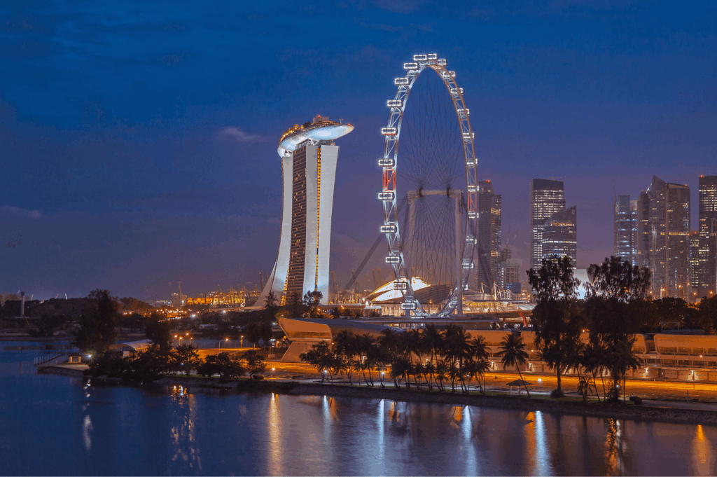 Nighttime panoramic views of Marina Bay Sands and the Singapore Flyer from a waterfront rooftop restaurant in the Marina Bay area at sea level with scenic views, showcasing the illuminated singapore skyline, city lights, outpost hotel, sky bar, and stunning views of downtown Singapore, Marina Bay Financial Centre, Ocean Financial Centre, Customs House, Collyer Quay, Civic District, Raffles Place, and OUE Bayfront. Ideal for dining with a view Singapore, this romantic restaurant offers alfresco balconies, private dining rooms, and rooftop dining with breathtaking views and sweeping vistas. Comparable to LAVO Italian Restaurant, Artemis Grill, Cé La Vi, Spago Bar, and La Vi, this dining room features seasonal ingredients, small plates, european classics, modern Asian cuisine, and contemporary Asian cuisine. Guests can dine on the freshest seafood including Maine lobster, enjoy signature cocktails during happy hour at the rooftop bar, lounge bar, and club lounge. One of the best rooftop restaurants and best rooftop bars in Singapore for a special dinner or weekday lunch with amazing views of Sentosa Island and Mount Faber Peak. Book ahead for an unforgettable night in the city.