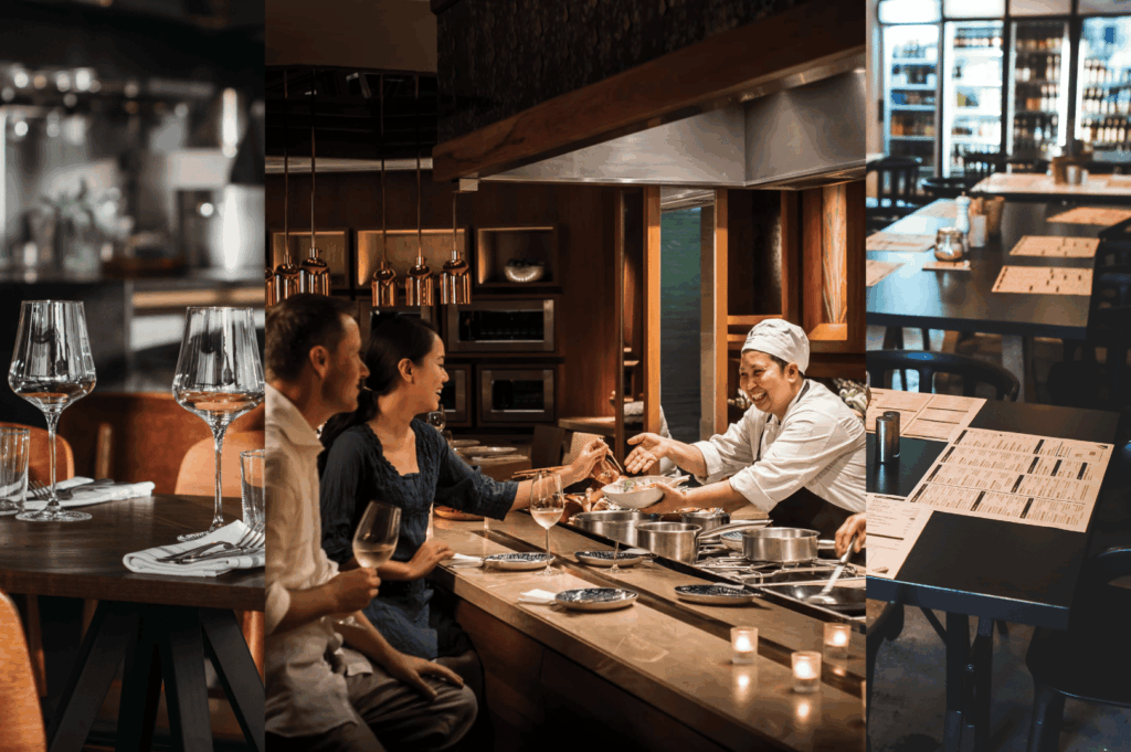 A multi-layered scene from a high-end restaurant capturing the essence of a chef’s table experience. On the left, a close-up of a warmly lit table set with wine glasses, napkins, and cutlery evokes anticipation. In the center, a smiling chef presents a dish to a guest seated at the counter, highlighting the intimacy and interaction of open-kitchen dining. Pots, pans, and candlelight frame the moment with authenticity and warmth. On the right, a wider view reveals more elegantly set tables and a glowing wine wall, reinforcing the luxurious, immersive atmosphere where guests become part of the culinary narrative.