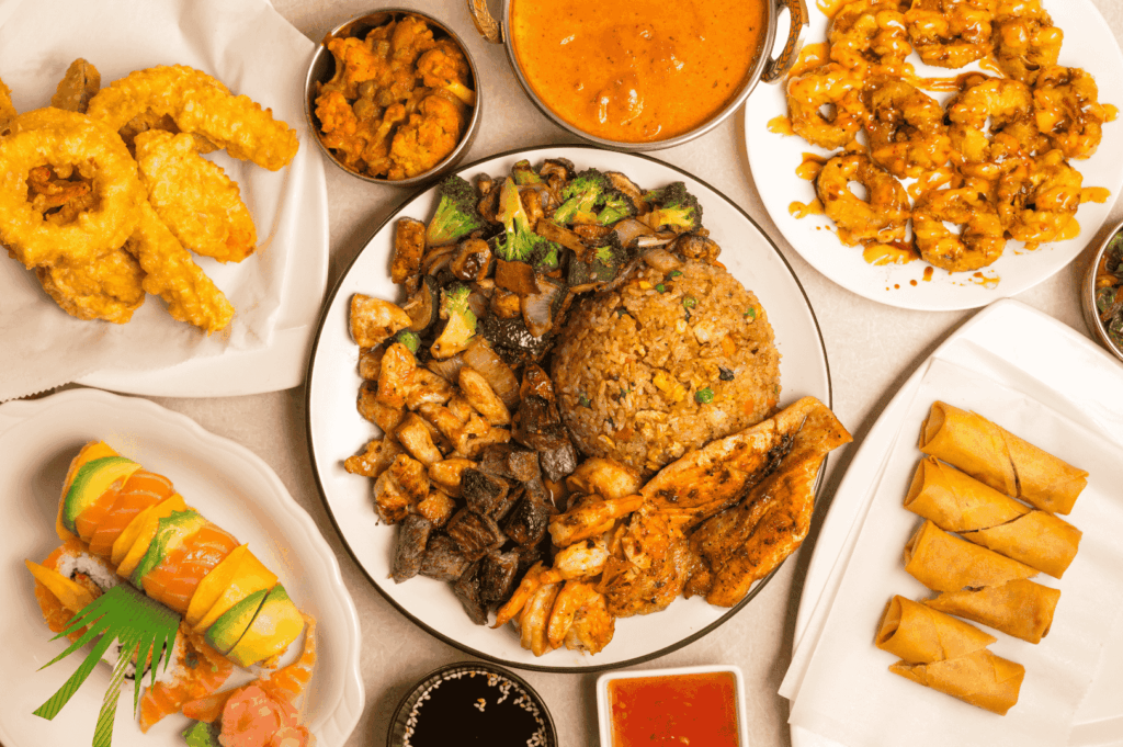 Assorted Singapore fusion dishes on white plates, blending Southeast Asian flavors with global techniques, overhead view