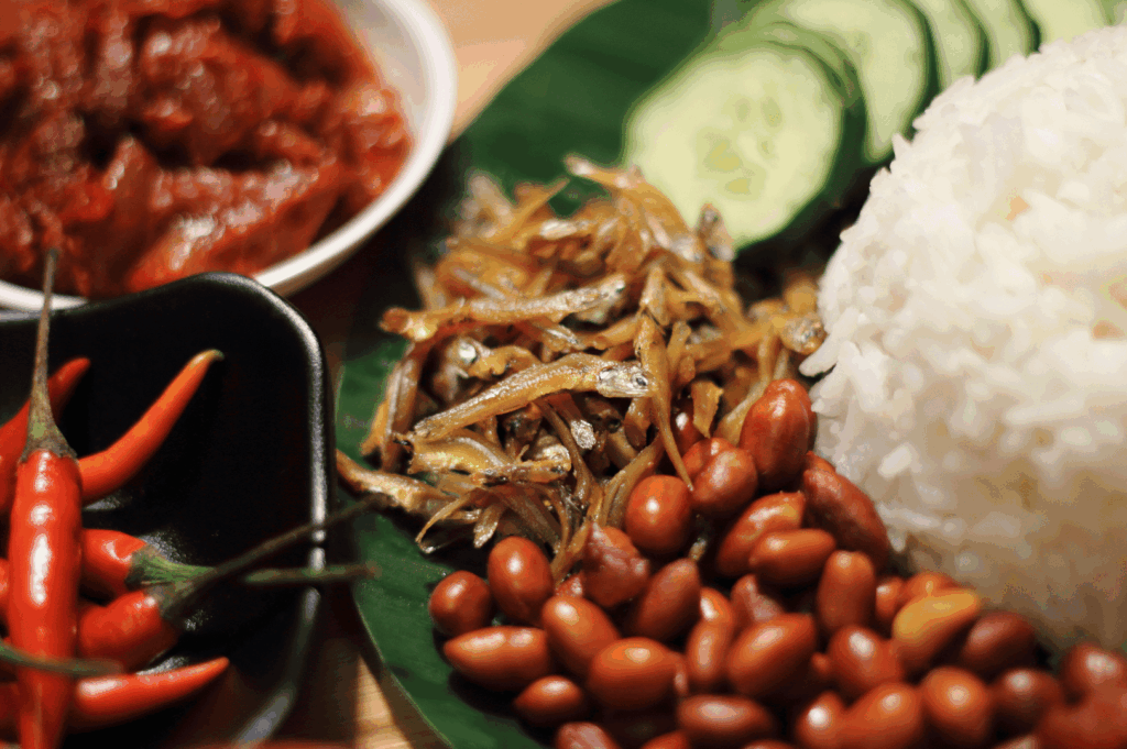 Top-down shot of a modern fusion plate with fragrant rice, spiced beans, fresh cucumber slices, and red chilis—evoking bold, global flavors in a Singapore dining context.