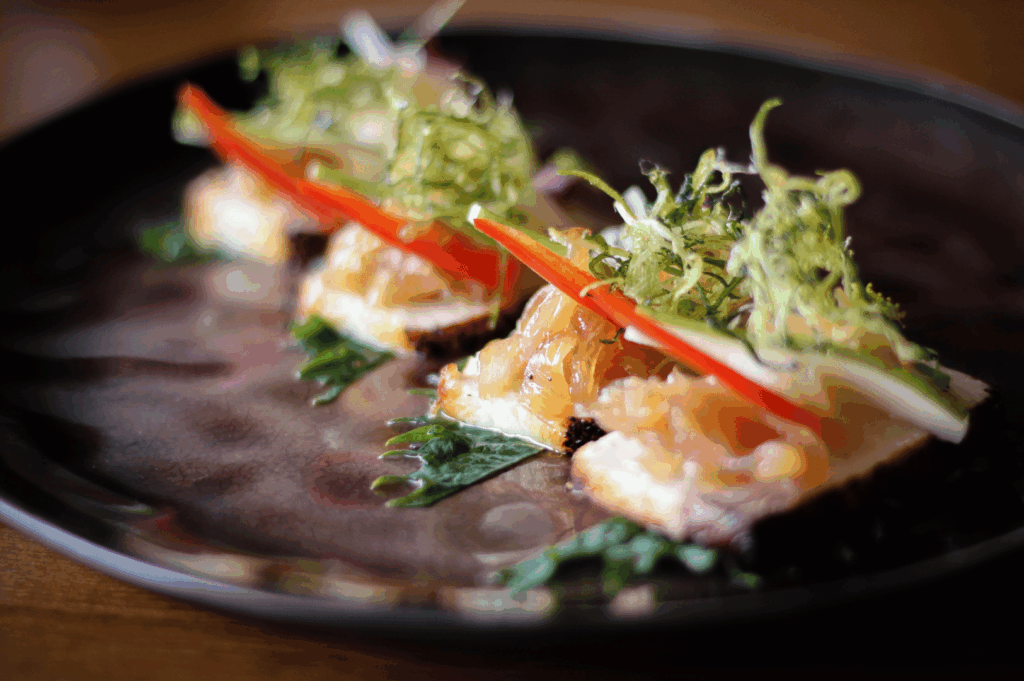 Plated gourmet dish on a rustic wooden table, showcasing refined plant‑forward presentation suitable for vegan fine dining in Singapore.