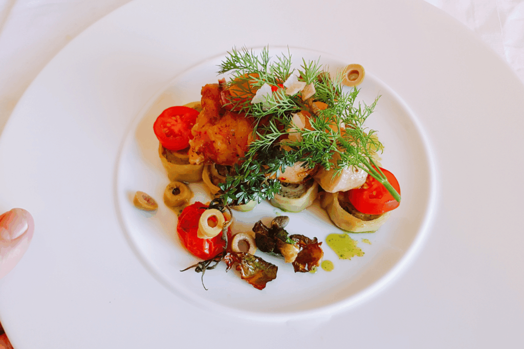 A plated vegan fine-dining dish in Singapore: artfully arranged vegetables and grains on a white plate, reflecting Michelin-level presentation