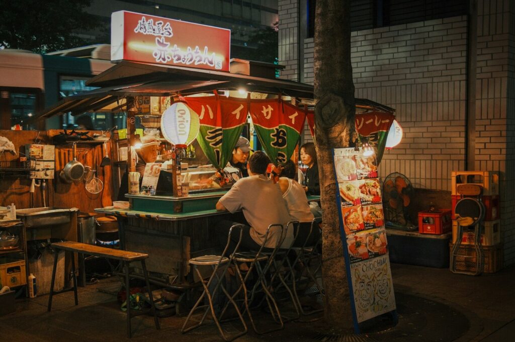A man at a table, relishing a Michelin-style meal in a hawker center food stall in singapore.