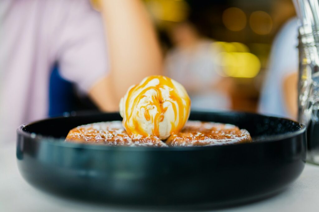 A black bowl filled with a dessert featuring a caramel apple, highlighting Singapore’s starred cuisines.