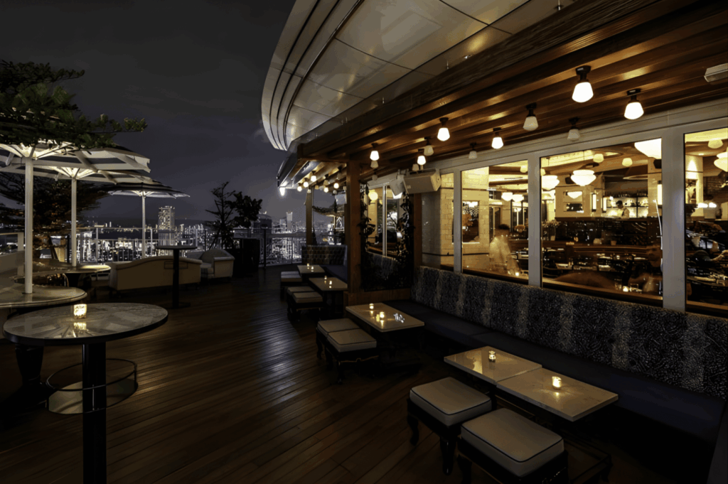 Elegant rooftop restaurant in Singapore at night with candlelit tables, string lights, and panoramic skyline views—highlighting the city’s rise in elevated dining experiences.