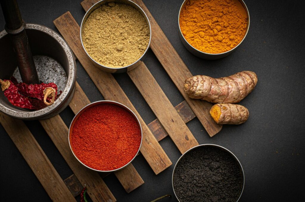 A variety of spices and herbs displayed in bowls, showcasing the rich culinary diversity of Singapore.