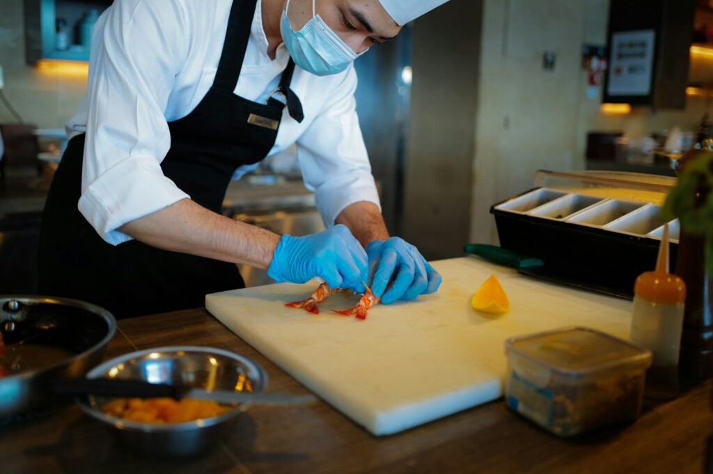 A chef is meticulously preparing an intricate dish, showcasing the artistry and precision that defines fine dining in one of Singapore's renowned Michelin-starred restaurants. The focus on quality ingredients and traditional flavors highlights the elegance and depth of the cuisine, perfect for special occasions.