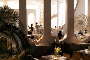 Elegant restaurant in Singapore filled with lush plants and patrons enjoying their meals in a vibrant atmosphere.