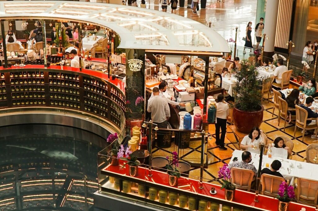 A bustling restaurant in Singapore filled with diners enjoying meals and drinks at various tables.