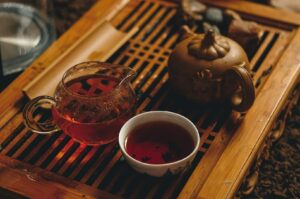 A wooden tray holds a teapot and a cup of tea, creating a tranquil scene in a Chinese tea room.