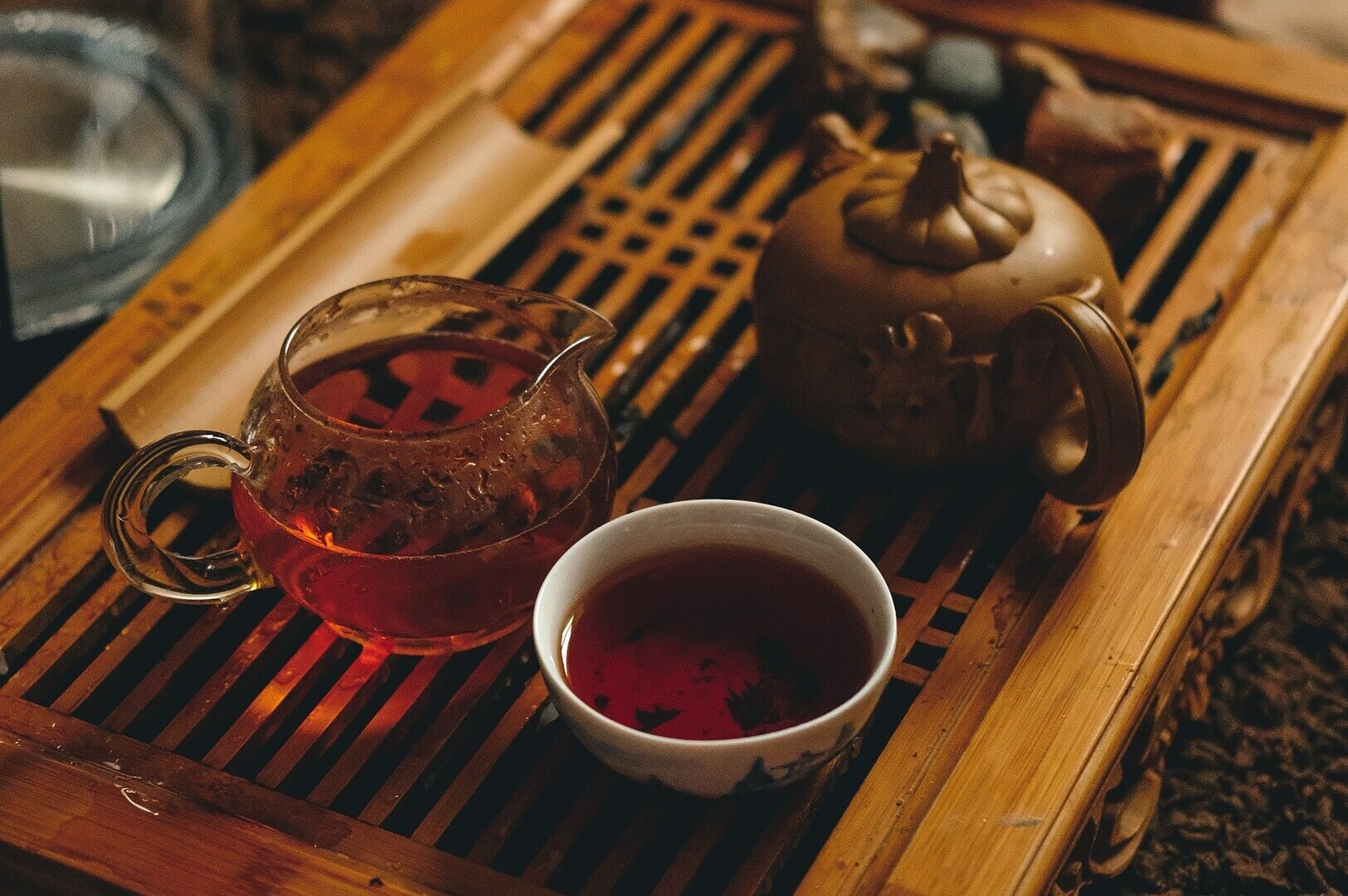 A wooden tray holds a teapot and a cup of tea, creating a tranquil scene in a Chinese tea room.