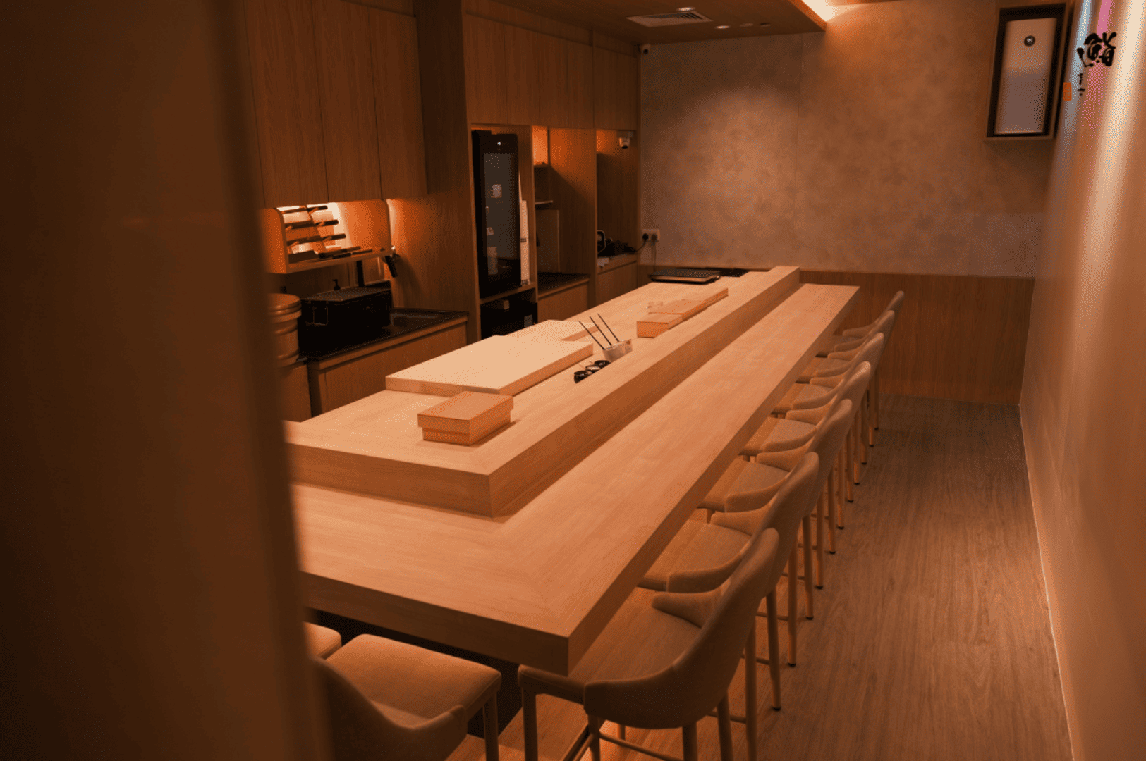 Interior view of Sushi Masa by Ki-setsu featuring a long bar with chairs and a sleek counter for patrons.