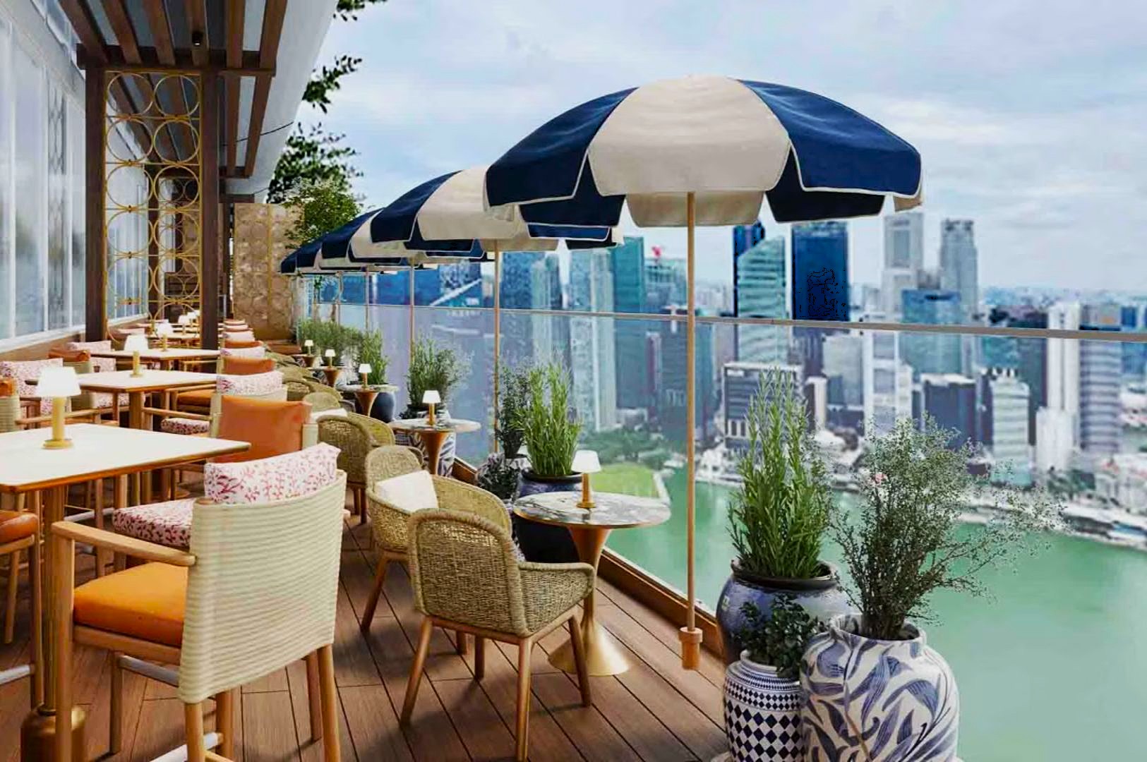 Rooftop terrace with wooden flooring, cozy seating, and blue-striped umbrellas overlooking a city skyline and river, creating a serene, elegant atmosphere.