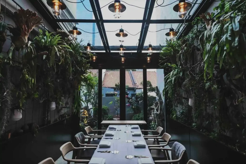 Luxurious dining room with red accents, elegant chandeliers, and long white tables set with plates and glasses. A sophisticated, inviting atmosphere.