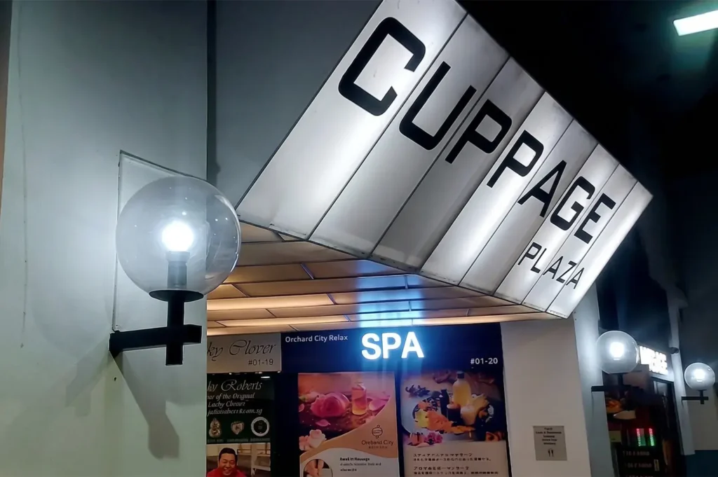 Cuppage Plaza building entrance sign with Orchard City Relax Spa storefront visible below.