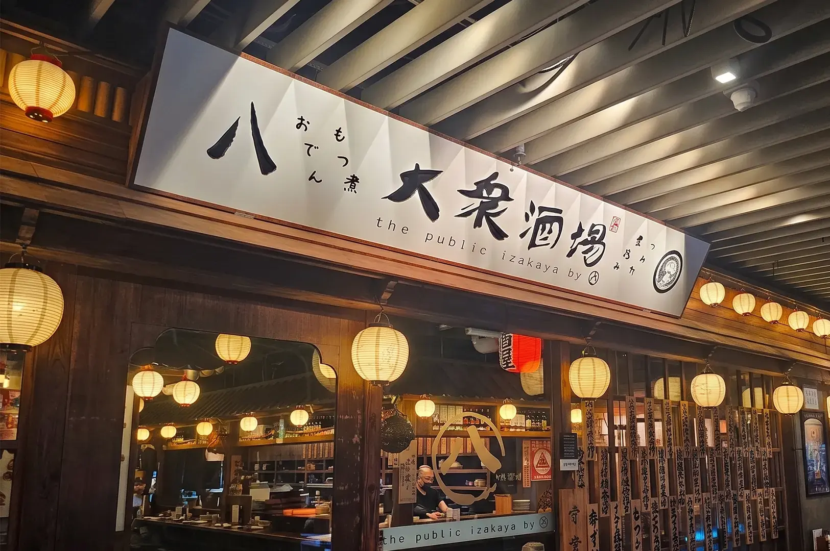 Facade of The Public Izakaya Japanese restaurant with traditional paper lanterns.